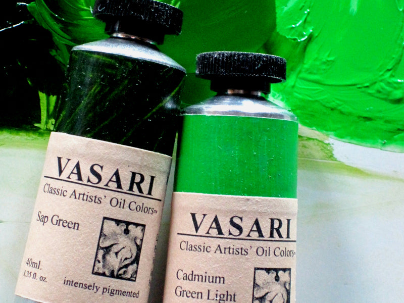 Close up of 40ml tubes of Sap Green at left next to Cadmium Green Light at right