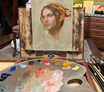 View of a portrait demo in the studio of painter Casey Childs with the colors of our Casey Childs Portrait Set arranged on his palette.
